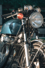 Fototapeta na wymiar close up of detail of classic style cafe racer motorcycle at sunset time. Bike custom made in vintage. Brutal fun urban lifestyle, vertical photo