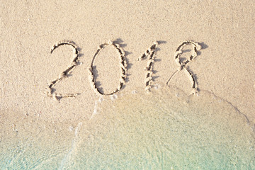 2018 written in the sea sand. Waves washed away the inscription.
