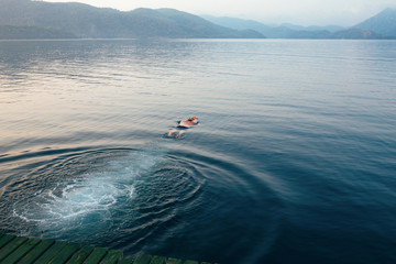 Man swimming in the erly morning. Tranquility concept, beautiful sea view.