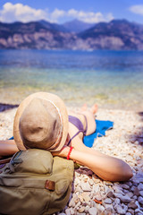 Fototapeta na wymiar Junge Reisende Frau liegt entspannt am Strand, Textfreiraum
