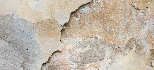 Textured grunge background. Old plastered wall with a multilayer cracked coating. Grunge texture with a deep pattern on whitewashed wall
