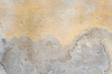 Textured grunge background. Old plastered wall with a multilayer cracked coating. Grunge texture with a deep pattern on yellow wall