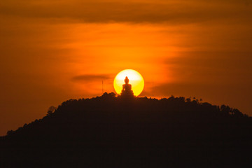 stunning red sky sunset the round sun is on the back of Phuket big Buddha on the high mountain...