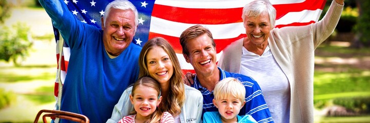 Multi-generation family holding american flag in the park