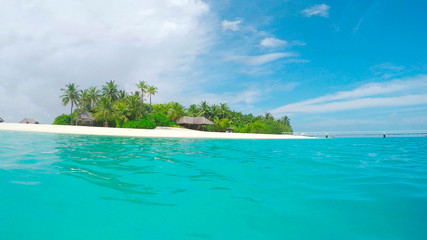 CLOSE UP: Female SUP boarding towards beautiful exotic Maldives island