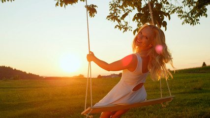 SLOW MOTION LENS FLARE Beautiful lady enjoying summer evening in golden twilight