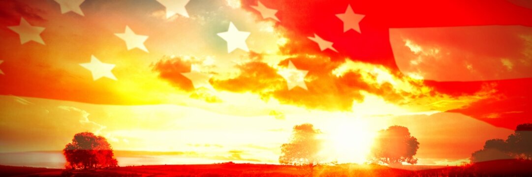 American flag rippling over landscape during sunrise