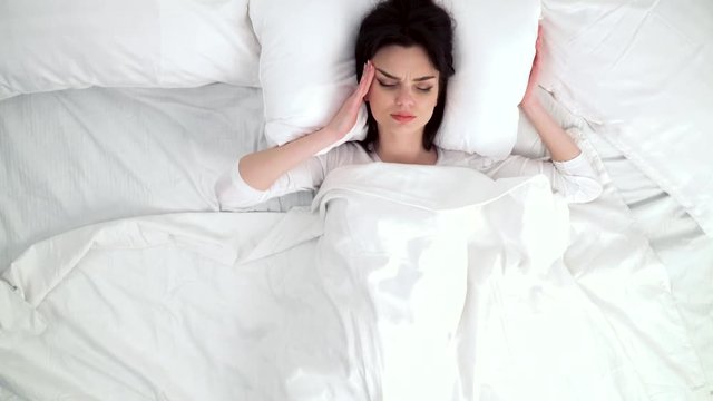 Woman Waking Up With Headache In Bed