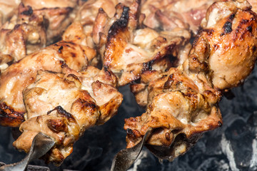 Grilled kebab cooking on metal skewer closeup. Roasted meat cooked at barbecue. BBQ fresh beef meat chop slices. Traditional eastern dish, shish kebab. Grill on charcoal and flame, picnic, street food
