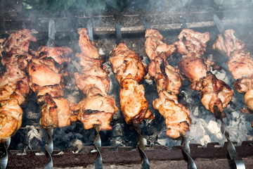 Grilled kebab cooking on metal skewer closeup. Roasted meat cooked at barbecue. BBQ fresh beef meat chop slices. Traditional eastern dish, shish kebab. Grill on charcoal and flame, picnic, street food