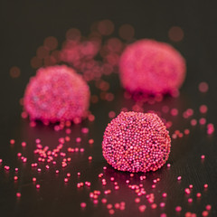 pink red berry brigadeiro brazilian sweet with sprinkles on black background