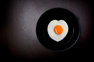 fried eggs in the shape of a heart in a frying pan