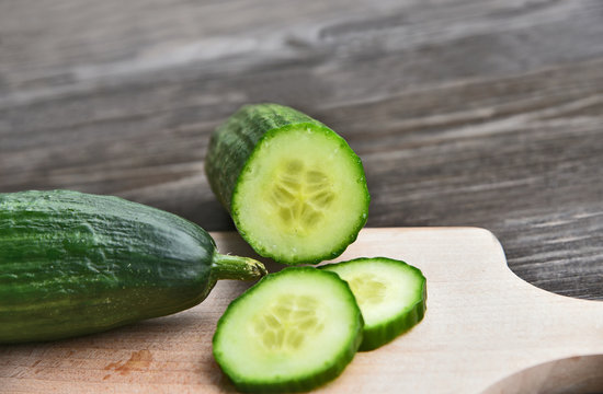 Cucumber seeds are edible and very nutritious..Fresh Cucumber slice on wooden board with wooden background.