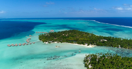 Fototapeta na wymiar Water bungalows resort at islands, french polynesia in aerial view