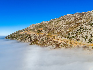 Aerial view of mountain range Velebit with cloud cover and blue sky, Zadar county, Croatia