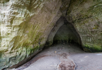 Natural cave in sandstone rock. Entrance to the cave called Little Hell in the Gauja National Park, Latvia. Close-up. Soft focus.