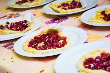 the child is preparing a pizza with berries. raspberry and strawberry.
