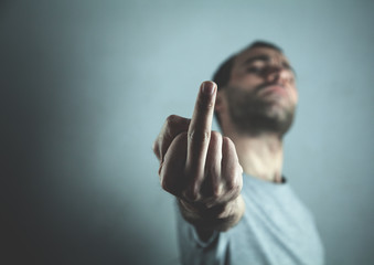 Caucasian aggressive man showing fuck you sign.