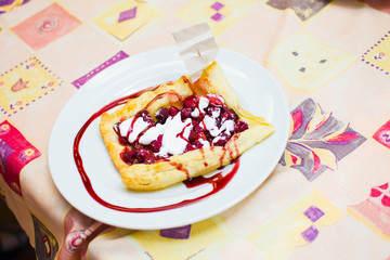 the child is preparing a pizza with berries. raspberry and strawberry.