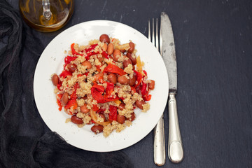 salad with quinoa on white plate on black background