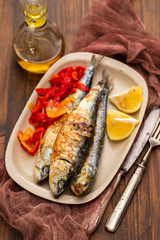 grilled sardines with red pepper and lemon on dish