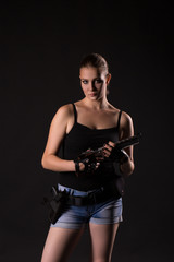 Military woman with a sport gun over black background