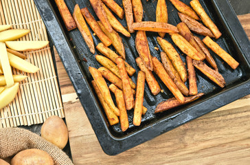 Crispy Oven Baked French Fries for healthy..French fries in black oven tray on wooden board.