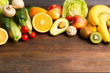 Various fruits and vegetables on wooden background with copy space