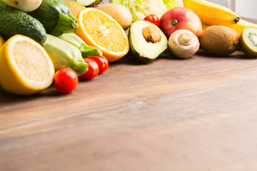 Citrus, apples and vegetables over wooden background