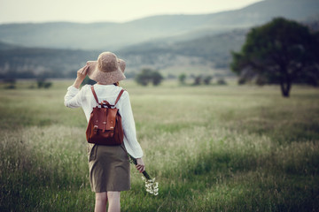 Young red-haired traveler in fairy-tale beautiful scenery.