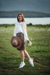 Young red-haired traveler in fairy-tale beautiful scenery.