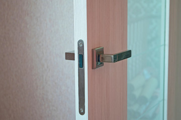 Open door in modern house. Modern wooden door with metal handle close-up detail. Interior product photography.