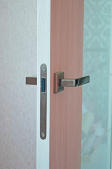 Open door in modern house. Modern wooden door with metal handle close-up detail. Interior product photography.