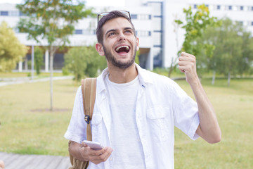 students with mobile phone or smartphone celebrating success