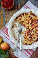 Homemade organic apple pie with cowberry on wooden background. Berry and fruits cake ready to eat....