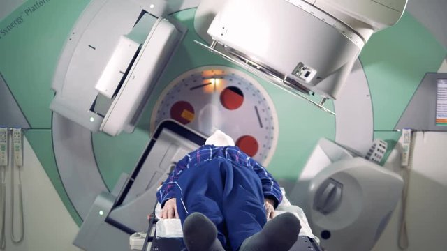 A man is getting radiated by a linear accelerator