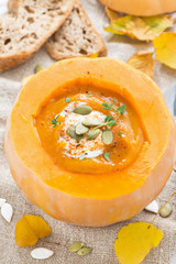 spicy vegetable cream soup in a pumpkin and bread