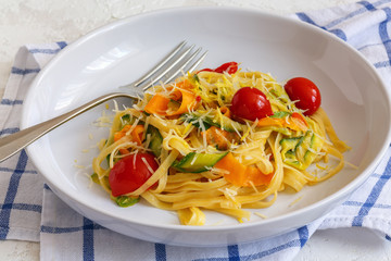 Homemade pasta with strips of zucchini and carrots.