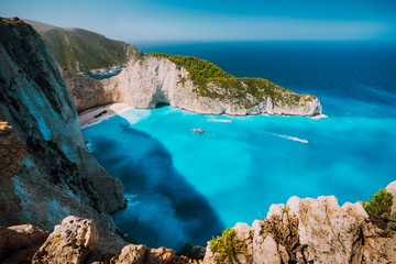 Navagio beach, Zakynthos island, Greece. Tourist boats visiting Shipwreck bay with azure water and paradise white sand beach. Famous landmark location in the world