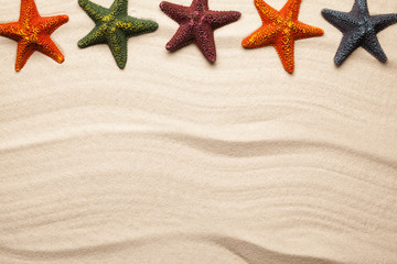 Fototapeta na wymiar Summer beach background - five starfish on sand