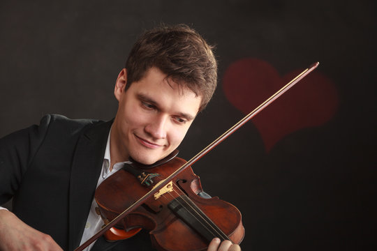 Man man dressed elegantly playing violin