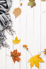 Autumn composition. Pattern made of dried leaves and scarf on white wooden background. Autumn flat background. Flat lay, top view, copy space 
