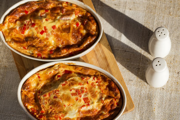 Two trays with baked omelette made from cheese, eggs, ham and red pepper