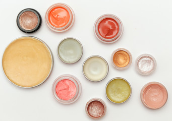 Creamy make up products - top view of decorative cosmetic containers isolated on white backgroiunds