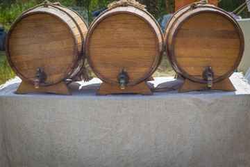 Three barrels for selling beer and wine on the bar table, outdoors on a sunny day, background with vignette and copy space