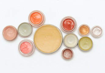 Creamy make up products - top view of decorative cosmetic containers isolated on white backgroiunds