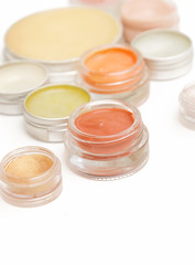 Cream eyeshadow, lip stain or blush in the jars - make up artist table, close up view