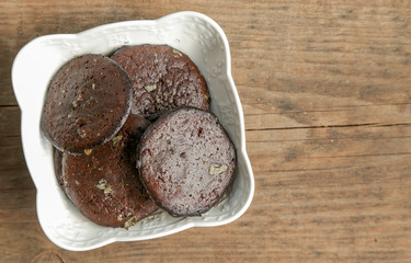 Top view of fresh baked cookies in a ceramic bowl on the wooden table with copy space 