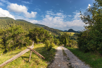 Rural gravel country road and old wooden fence in village on Zaovine Lake in Serbia