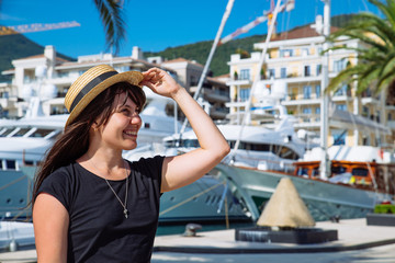 smiling woman portrait at dock with yachts on background